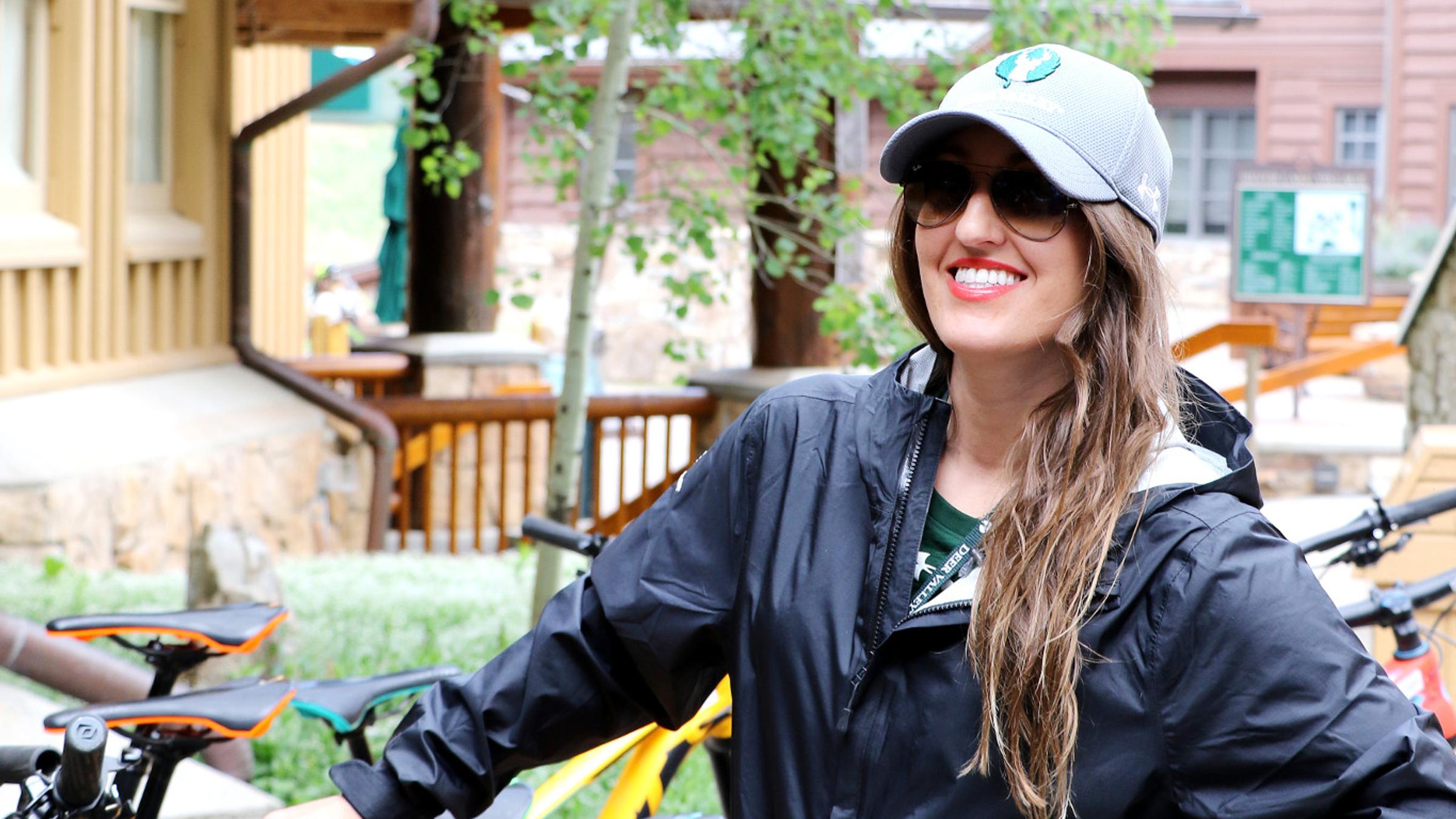 Deer Valley employee smiles with mountain bikes